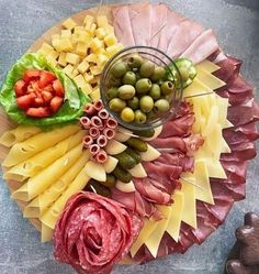 a platter filled with meats, cheese and olives