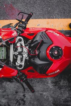 a red motorcycle parked on top of a parking lot