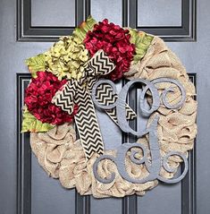 a monogrammed wreath with flowers on the front door