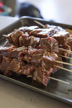 meat skewers on a tray with toothpicks sticking out of the top