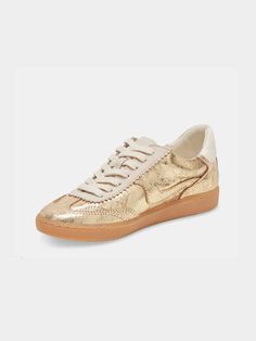 These gold distressed leather sneakers are the perfect combination of luxury and casual style. Designed with a metallic gold finish, these sneakers add a touch of glamour to any outfit while maintaining a relaxed, easygoing vibe. The distressed leather gives them a unique, worn-in look, adding character and making them a standout piece in your wardrobe. The sneakers feature a classic low-top silhouette with white laces and a contrasting white textured heel tab for added style. The gum rubber sol Black Date Night Outfit, Black Dating, Nashville Style, Bride Accessories, Platform Sandals Heels, Playsuit Romper, Crossbody Clutch, Sneaker Wedge, Distressed Leather