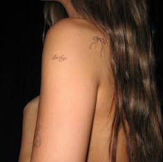 the back of a woman's shoulder with tattoos on her left arm and chest