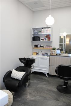 a salon with black chairs and white cabinets