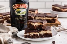 a bottle of bailey's irish chocolate brownies next to three pieces of cake