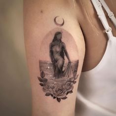 a woman's arm with a tattoo on it and a moon above her shoulder