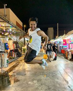 a man is jumping in the air to catch a frisbee at an outdoor market