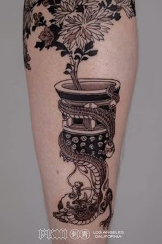 a woman's leg with tattoos and flowers on it