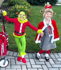 two children dressed up as santa claus and grin - face, walking down the sidewalk