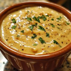 a brown bowl filled with soup on top of a table