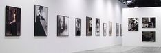 an art gallery with white walls and black and white pictures on the wall, all hanging up