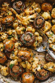 mushrooms and cauliflower are being cooked in a pot with a serving utensil