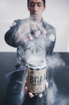 a man is sprinkled with sugar on his hand and holding a coffee cup