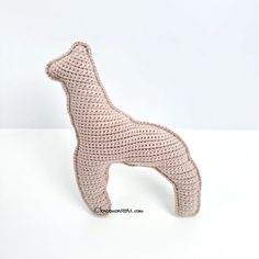 a crocheted dog is standing on its hind legs and it's tail up