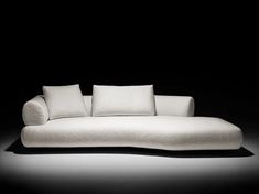 a white couch sitting on top of a black floor