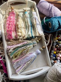 a white tray filled with lots of different colored beads and crochet hooks on top of a table