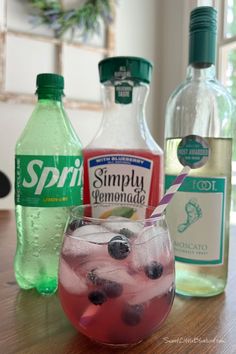 Photo of a moscato wine spritzer in a short wine glass made with Blueberry Lemonade garnished with fresh blueberries with a purple and white straw. A bottle of sprite, blueberry lemonade and moscato are behind the glass. Wine Spritzer Recipe, Easy Lemonade, Almond Joys, Peach Cobbler Pound Cake, Buttermilk Muffins, Spritzer Recipes, Moscato Wine, Wine Spritzer, Cocktail Drinks Alcoholic