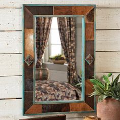 a mirror sitting on top of a table next to a potted plant