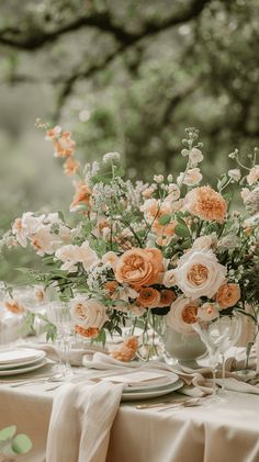 an arrangement of flowers in vases on top of a table with plates and napkins