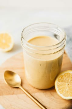 a glass jar filled with liquid next to sliced lemons on a wooden cutting board