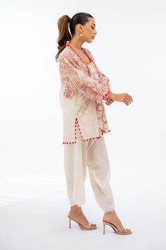 A luxe khaddi corduroy jacket is adorned with crimson hued embroidery in our signature floral imagery. Puffy sleeves with embroidered cuffs add a playful element to the ensemble. Ivory box pants are paired with a geometric embroidered crepe slip. Model Height is 5'5 and Shirt Length is 30' Chic Embroidered Festive Sets, Chic Festive Sets With Floral Embroidery, Elegant Cotton Palazzo Set For Spring, Elegant Spring Cotton Palazzo Set, Spring Cotton Sets With Embroidered Sleeves, Spring Long Sleeve Kurta With Embroidered Cuffs, Spring Kurta With Embroidered Cuffs And Long Sleeves, Long Sleeve Sets With Embroidered Hem For Spring, Spring Sets With Embroidered Long Sleeves