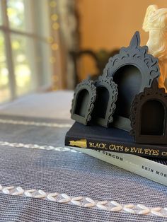 three black cats and evil eyes club bookends on top of a tablecloth