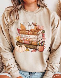 🍂 Fall Pumpkin Sweatshirt | Thanksgiving T-Shirt | Book Lover Shirt 🍁 Embrace the warmth and coziness of fall with this delightful pumpkin-themed sweatshirt! Perfect for those who love the autumn season, this soft and comfy sweatshirt captures the essence of fall with a charming pumpkin design. Whether you're spending time with family on Thanksgiving or curling up with a good book, this sweatshirt is just for you! Seasonal Style: Ideal for cool fall evenings and cozy days at home, keeping you warm and stylish. Pumpkin Love: Features a chic and minimal pumpkin design, the quintessential symbol of fall. Perfect for Book Lovers: A great gift for those who love reading, combining the joy of books and the beauty of autumn. Thanksgiving Ready: Complete your look for family gatherings or fall o Fall Bookish Tops With Graphic Print, Fall Graphic Print Bookish Tops, White Bookish Sweatshirt With Letter Print, Relaxed Fit Bookish Sweatshirt For Fall, Fall Bookish T-shirt With Letter Print, Bookish Fall T-shirt With Letter Print, Autumn Hoodie, Fall O, Sweat Women