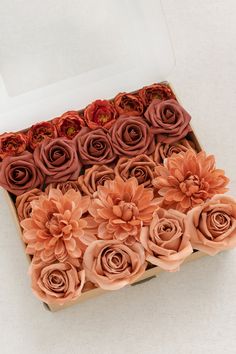 an open box filled with flowers on top of a table