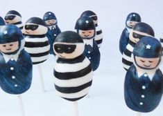 there are many police cake pops on the stick in the shape of people wearing black and white stripes