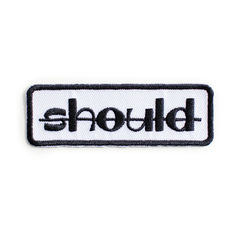 a black and white patch with the word shold on it's back side