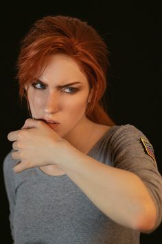 a woman with red hair is posing for the camera