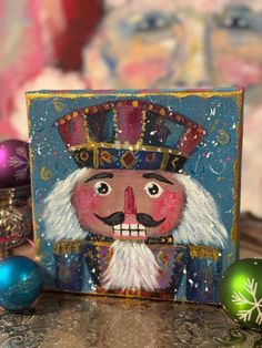 a painting of a nutcracker on a table next to christmas ornaments and decorations