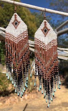 Beaded fringe earrings with western flavor. glass seed beads in white, clear, bronze, black, and a fun turquoise tip. Artisan White Earrings With Beaded Fringe, White Beaded Fringe Earrings For Festival, White Bohemian Fringe Earrings, Southwestern Style White Earrings For Festivals, White Beaded Fringe Festival Jewelry, Artisan White Fringe Jewelry, Festival White Beaded Fringe Jewelry, White Southwestern Beaded Earrings For Festivals, Southwestern White Beaded Earrings For Festival