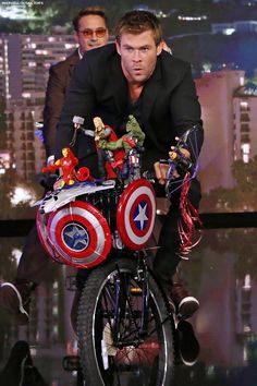 a man riding on the back of a bike with captain america decorations all over it