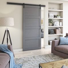 a living room filled with furniture and a large sliding door in front of a bookshelf