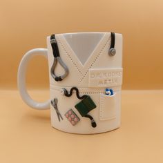 a white mug with scissors and other items on it