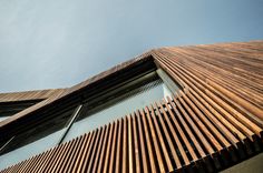 the side of a building with wooden slats on it's sides and sky in the background