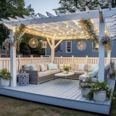 an outdoor living area with couches and lights on the pergolan roof, surrounded by potted plants