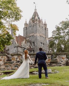 the bride and groom are walking towards an old castle