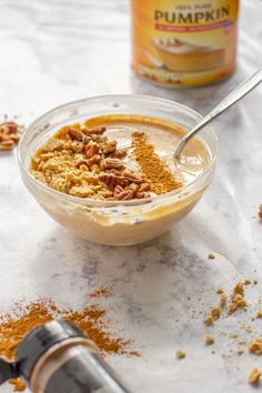 a bowl filled with food sitting on top of a table next to a jar of peanut butter