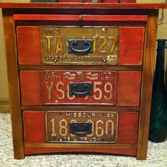 three drawers with different numbers on them in a room next to a vase and other items