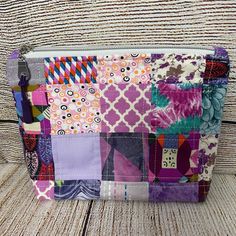 a colorful patchwork purse sitting on top of a wooden table