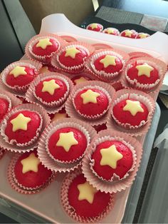 red velvet cupcakes with white icing and stars on them in pink cases