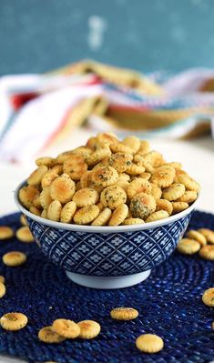 a blue and white bowl filled with crackers on top of a blue place mat