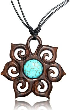 a necklace with a turquoise stone in the center and an intricate design on it's side