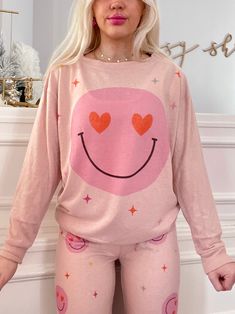 Our Hearts and Charms Smiley PJ Set in pink is super soft and comfy to lounge around! Hearts act as the smiley face eyes on the top. Also available in white! fit: these RUN SMALL - size up 1 size more than your normal model normally wears a small and is wearing a medium in this photo Trendy Pink Relaxed Fit Sleepwear, Playful Pink Sleepwear With Relaxed Fit, Comfy Super Soft Pink Sleepwear, Trendy Heart Graphic Tops For Loungewear, Trendy Heart Print Tops For Loungewear, Playful Pink Relaxed Fit Sleepwear, Trendy Pink Sleepwear For Lounging, Trendy Loungewear Tops With Heart Graphic, Fun Pink Tops For Loungewear