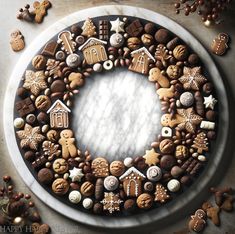 a christmas wreath made out of cookies and other holiday treats on a plate with snowflakes