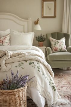 a white bed sitting in a bedroom next to a green chair and table with flowers on it