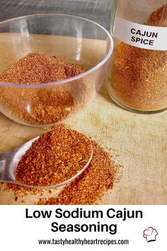 two bowls filled with red cajun seasoning on top of a wooden table