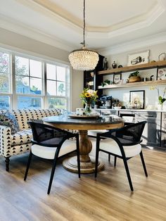 a dining room table with chairs and a chandelier hanging from it's ceiling