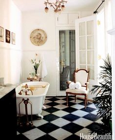 a bathroom with a checkered floor and chandelier above the bathtub is shown